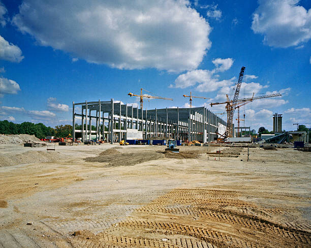 Construction site with a steel frame and cranes.